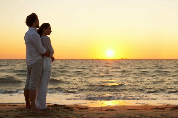 Pareja juntos en la orilla del mar de la tarde