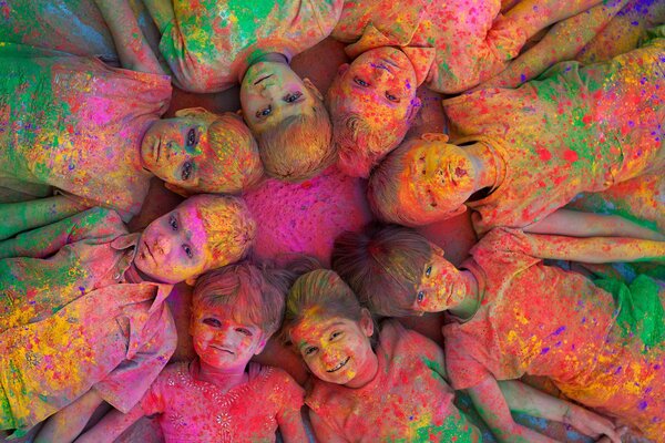 Dzieci malowane farbami leżą na słońcu bawiąc się