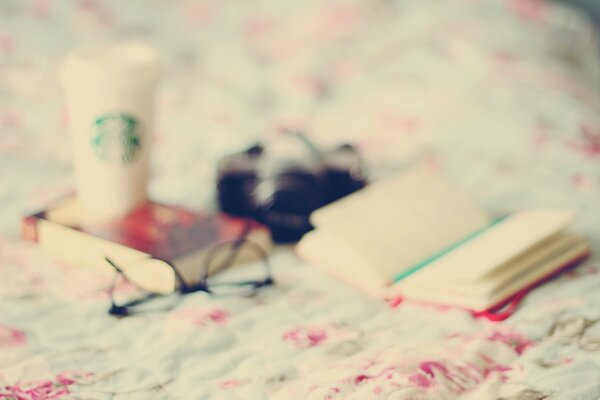 There is a book glasses and a glass on the table