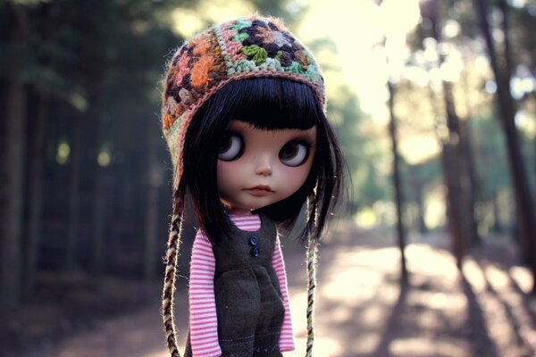 Eine Puppe mit dunklen Haaren, großen Augen in einer Mütze