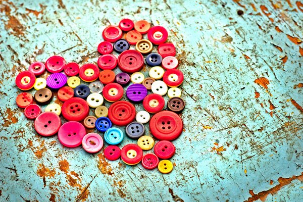 Corazón de botones de colores en la mesa