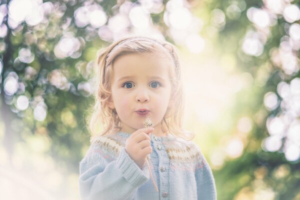 Niña sopla diente de León