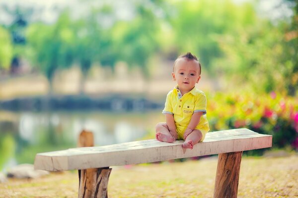 A little boy sitting on a bench