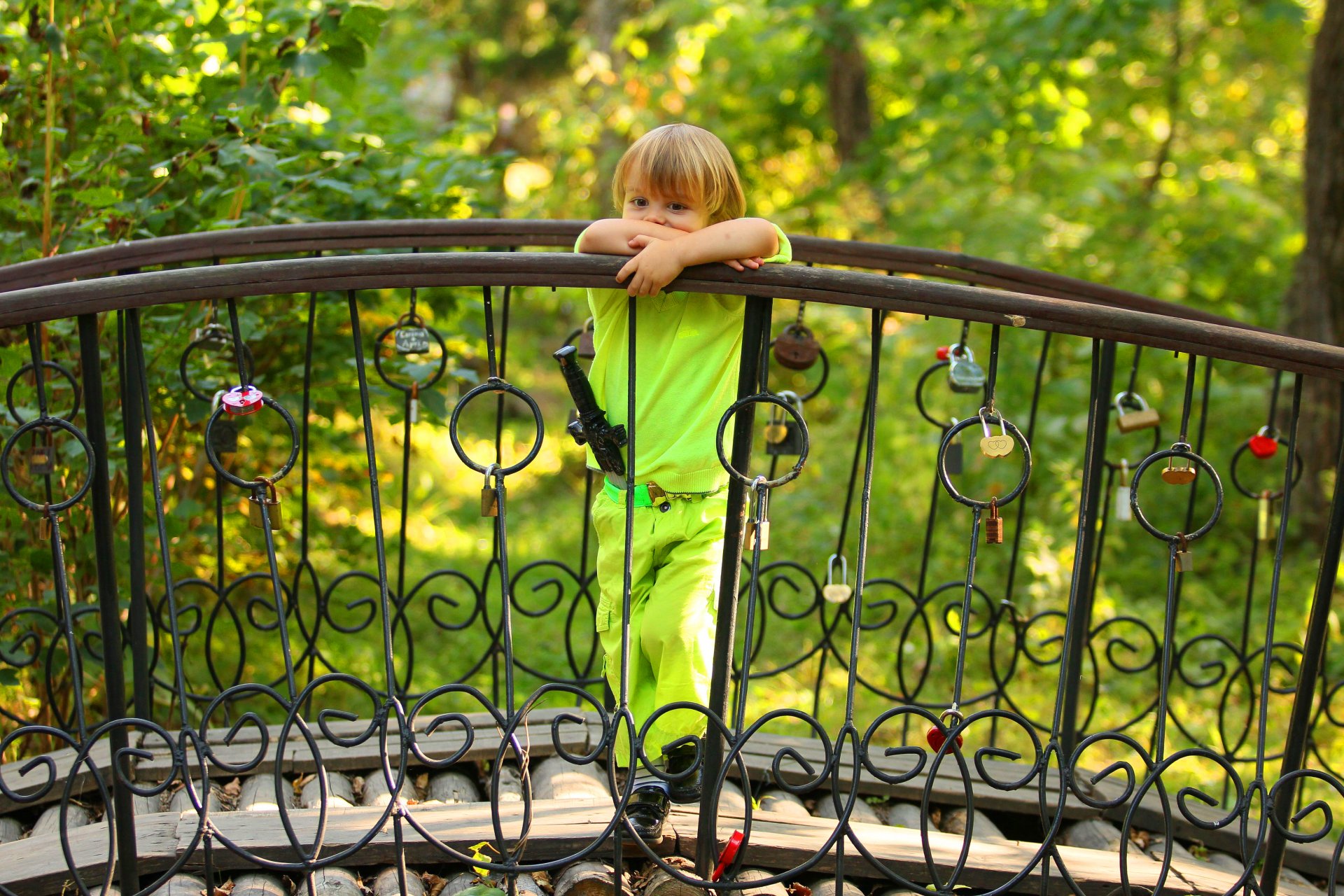 ragazzo bambino biondo posa pensosità spada costume ponte alberi recinzione castelli cuori estate verde