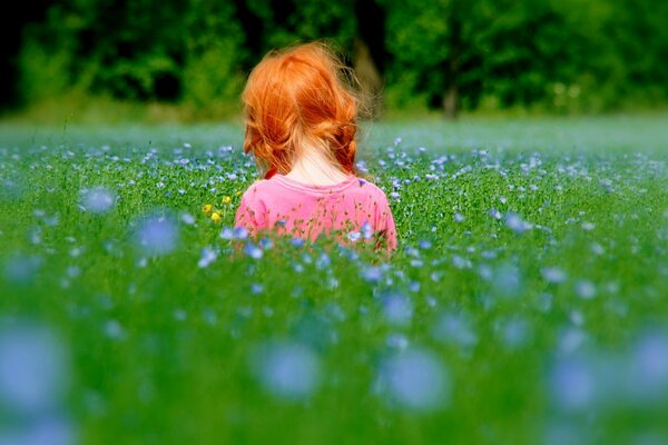 Sonniges Mädchen mit roten Haaren mit Radieschen Gras