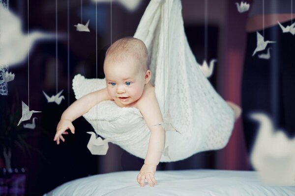 A beautiful baby is smiling happily lying in a pillow