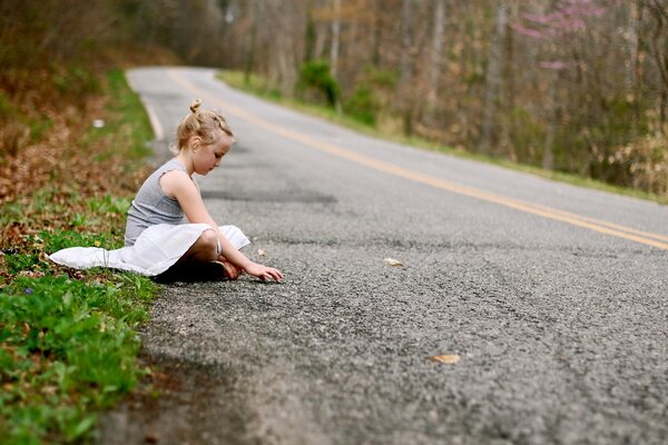 Chica sentada en el camino