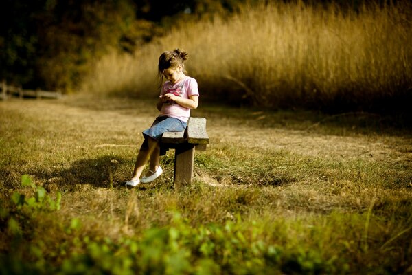 Fille dans la nature assis sur un banc