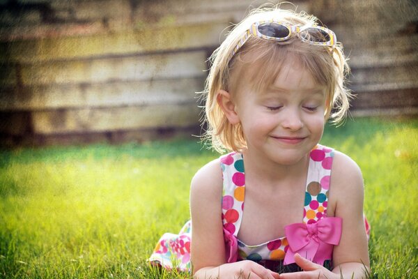 Jeune fille souriante avec les yeux fermés se trouve sur l herbe