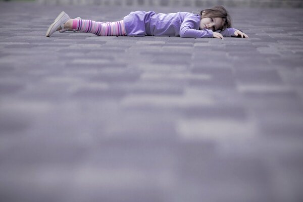 Niña acostada en la calle