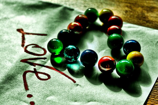 Glass balls in the shape of a heart and with the inscription love on paper.