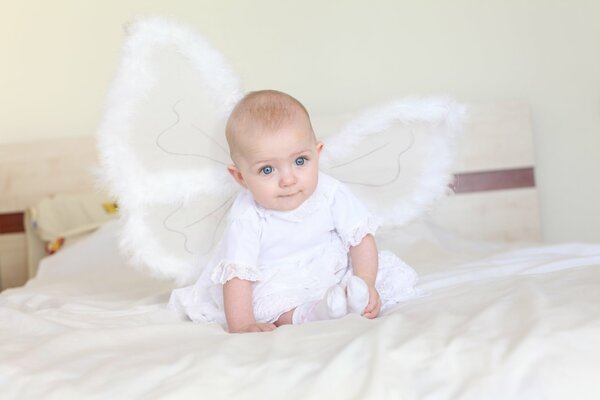 A girl with angel wings on the bed