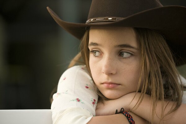 Freckled sad girl in a hat