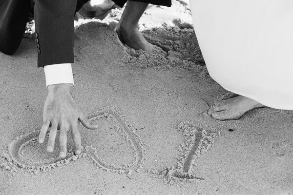 Photo voûtée en noir et blanc des pieds des jeunes mariés