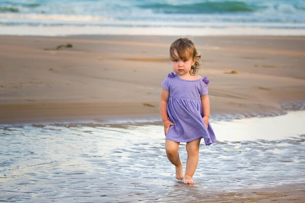 A girl in shallow water, a girl in a lilac dress