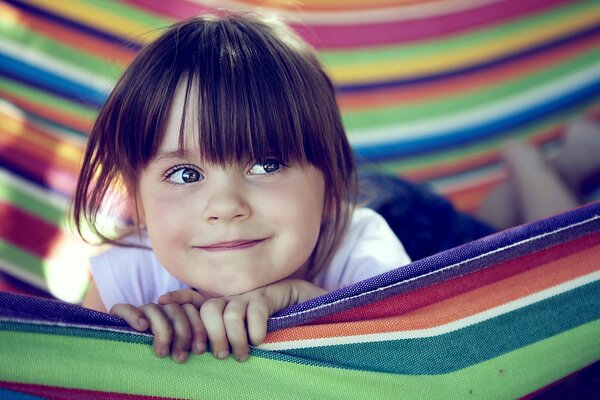 Cute girl in a striped hammock