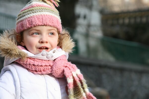 Baby in a warm hat and scarf on a walk