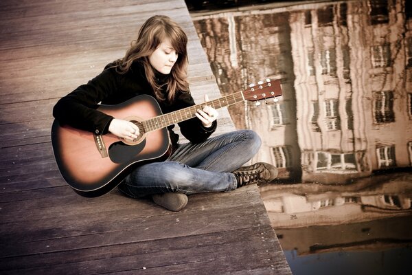 The girl plays her favorite guitar