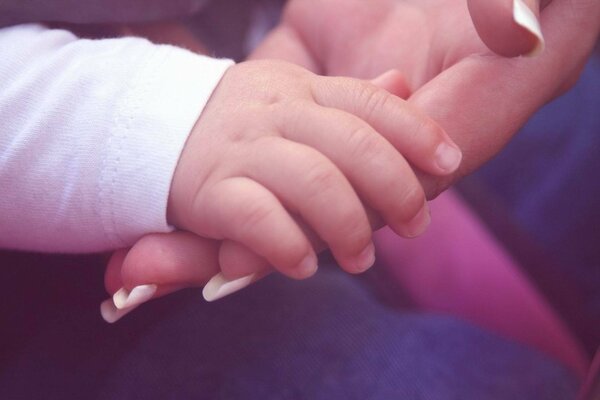 Hand in hand:baby s palm in mom s palm