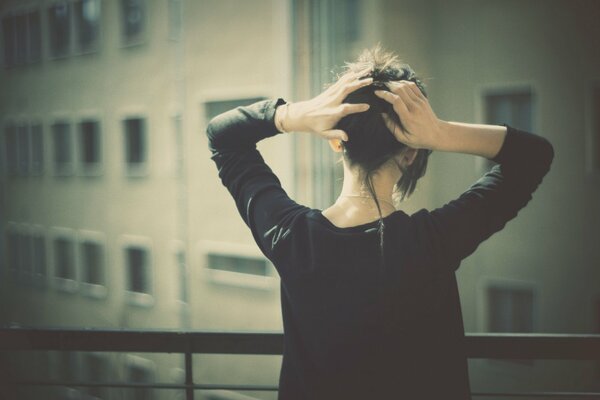 A girl on the balcony admires the cityscape