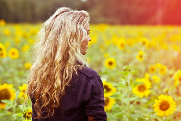 A bright picture of a girl in a field of sunflowers