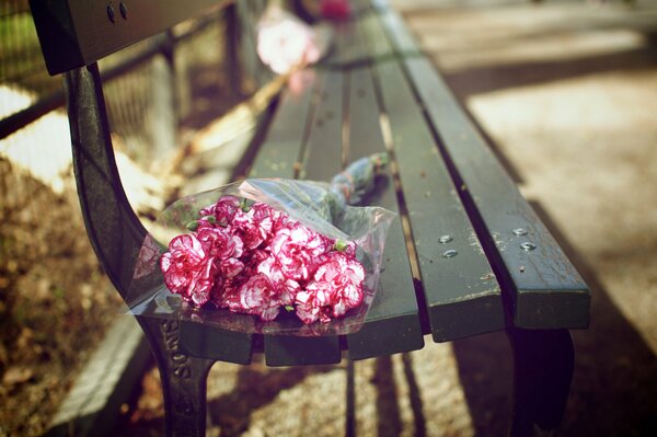 A bouquet of flowers forgotten on a bench
