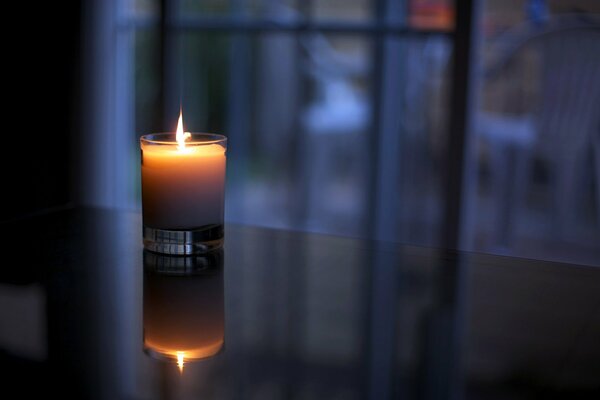 The candle is burning comfortably on the table