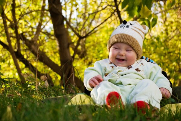 Lachendes Baby auf dem Rasen im Park