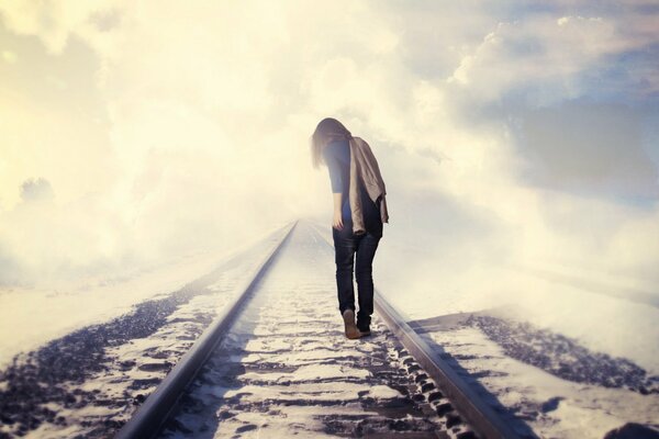 A girl walks on the railway