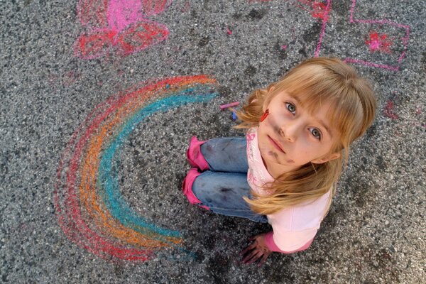 Испачкавшаяся девочка нарисовала на асфальте радугу