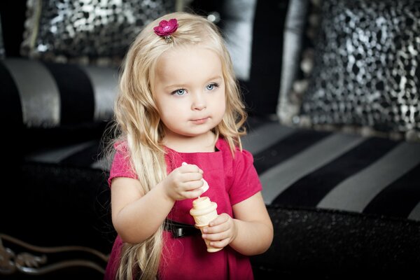 Una ragazza in un vestito rosa mangia il gelato