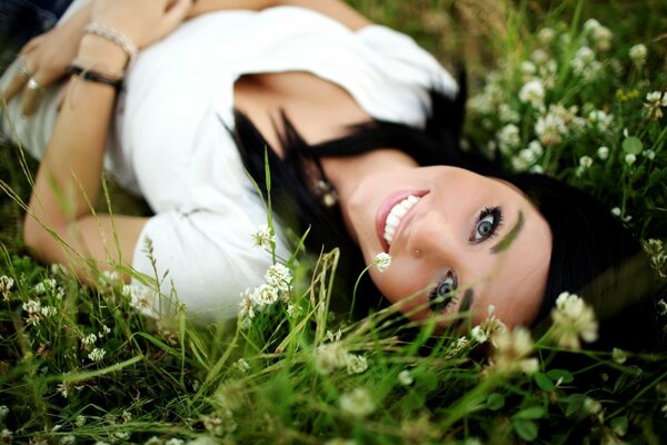 Una morena sonriente en un Prado verde