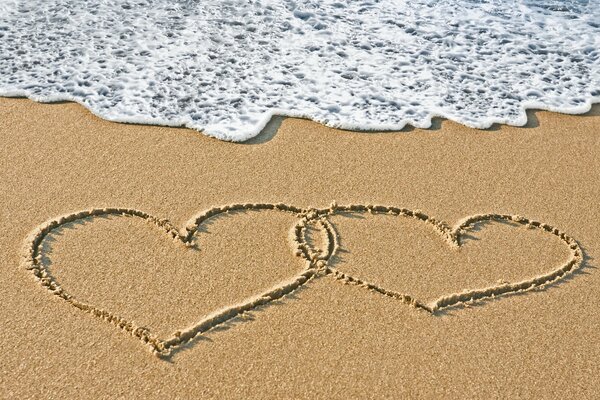 Drawing of two hearts on the seashore