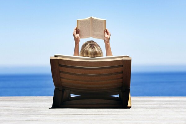 Ragazza in vacanza in riva al mare con il libro