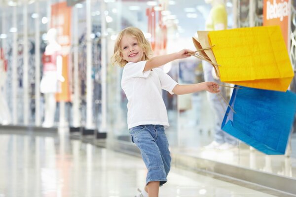 Glückliches Kind mit Paketen beim Einkaufen