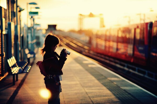 Sulla vogsal, una ragazza scatta foto di un treno