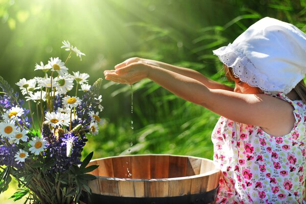 Wasser in den Handflächen tropfen auf Blumen