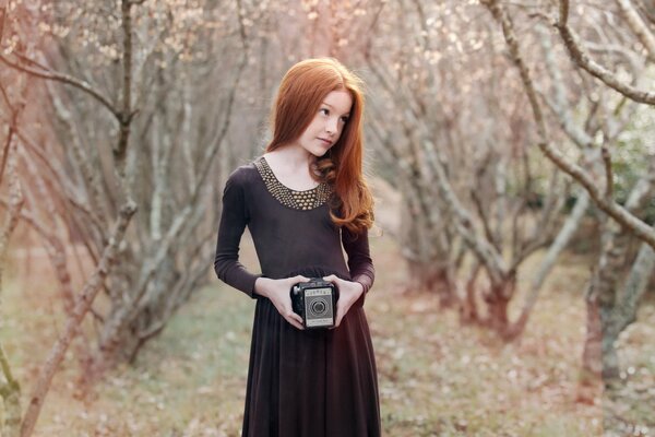 Beautiful girl with a camera in a dress