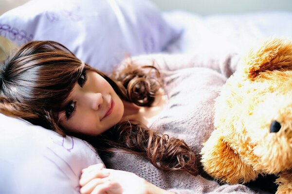 A girl with a teddy bear. Pajamas