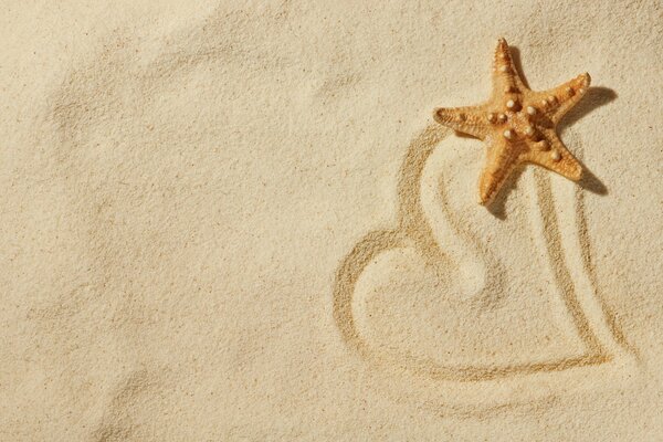 Gezeichnetes Herz auf dem Sand mit einem Stern
