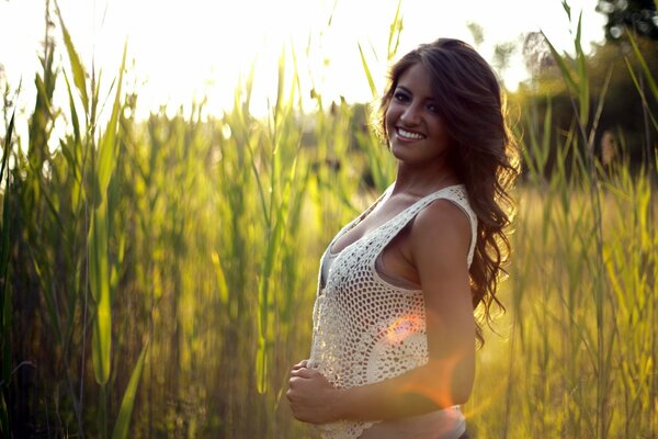 A girl in the summer on a meadow in the grass