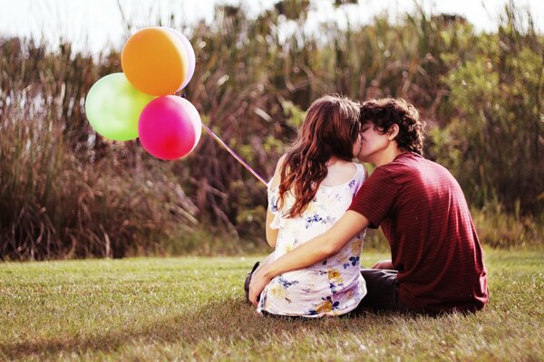 Joven pareja besándose con globos