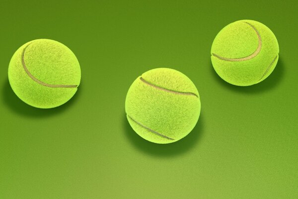 Trzy żółte piłki tenisowe na zielonym tle