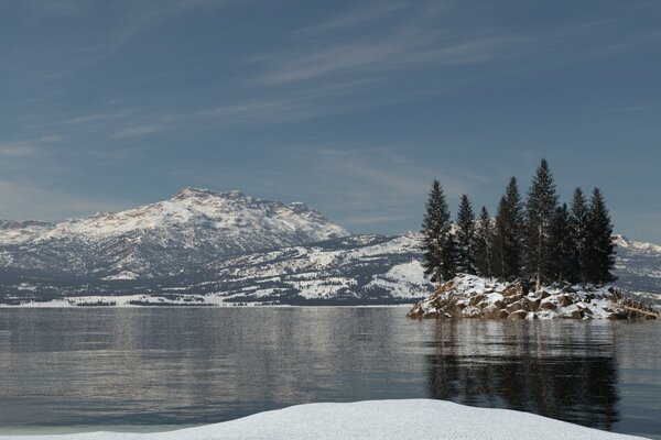 Rocky island with Christmas trees in the middle of the lake