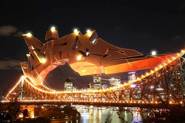 A bridge of three-dimensional metal graffiti in the evening lights