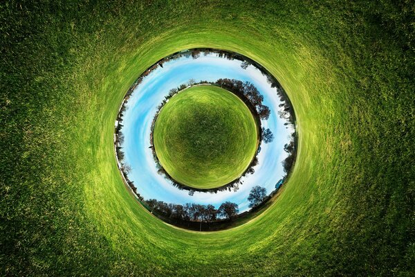 A circle of water and green grass around