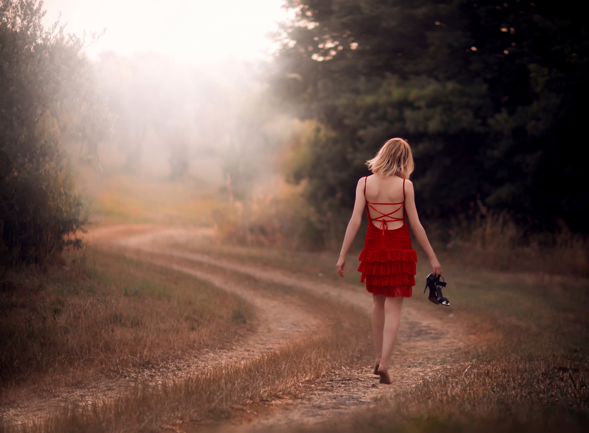 girl barefoot in red road the field the way