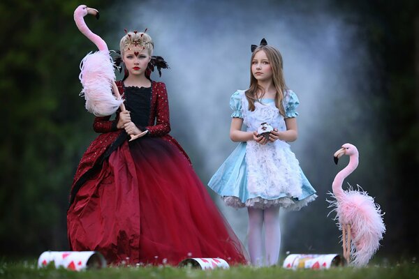 Two beautiful girls in dresses and flamingos