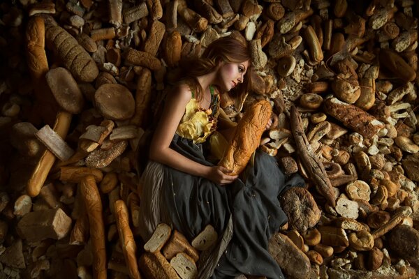 Modello di ragazza si trova in una varietà di pagnotte di pane