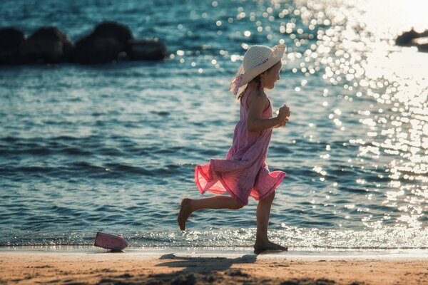Девочка бежит по берегу за корабликом